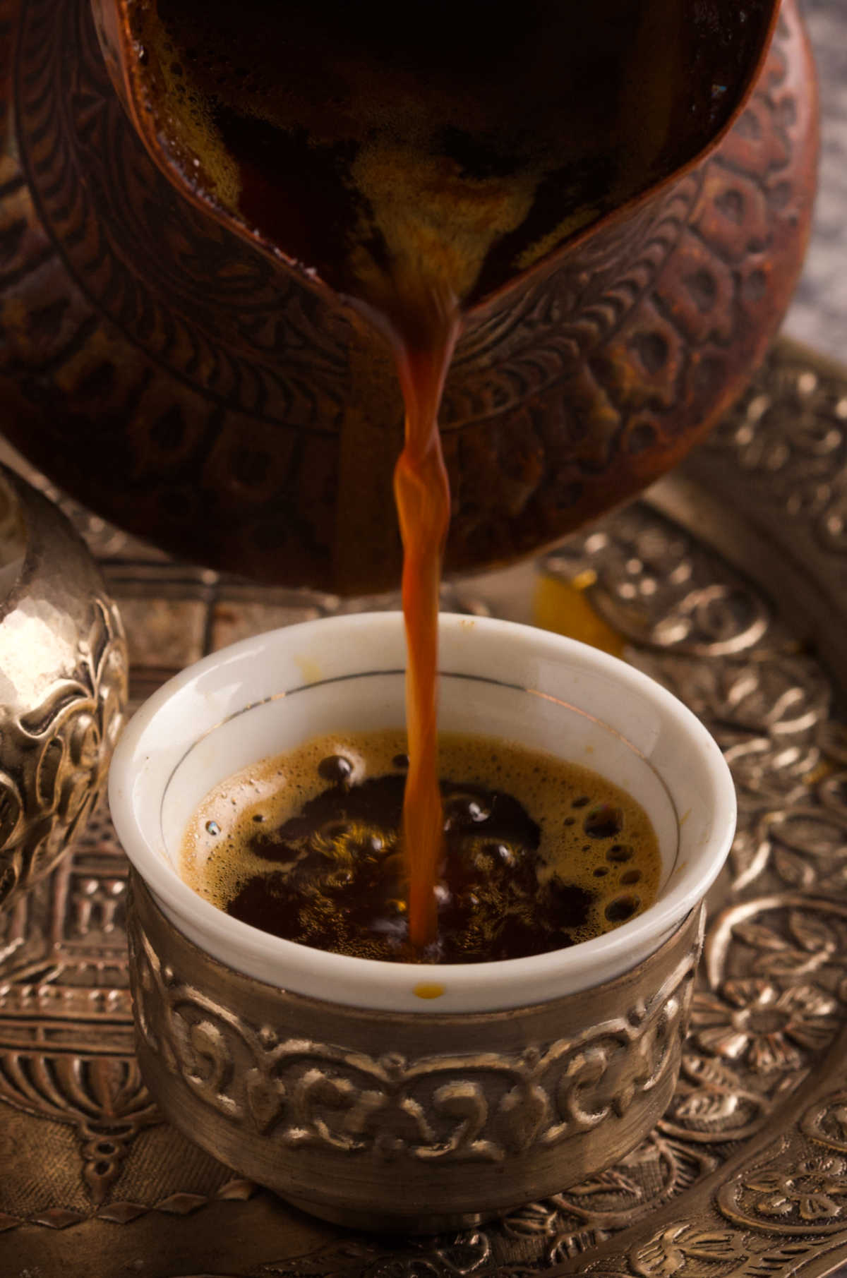 Coffee being poured into a small coffee cup.