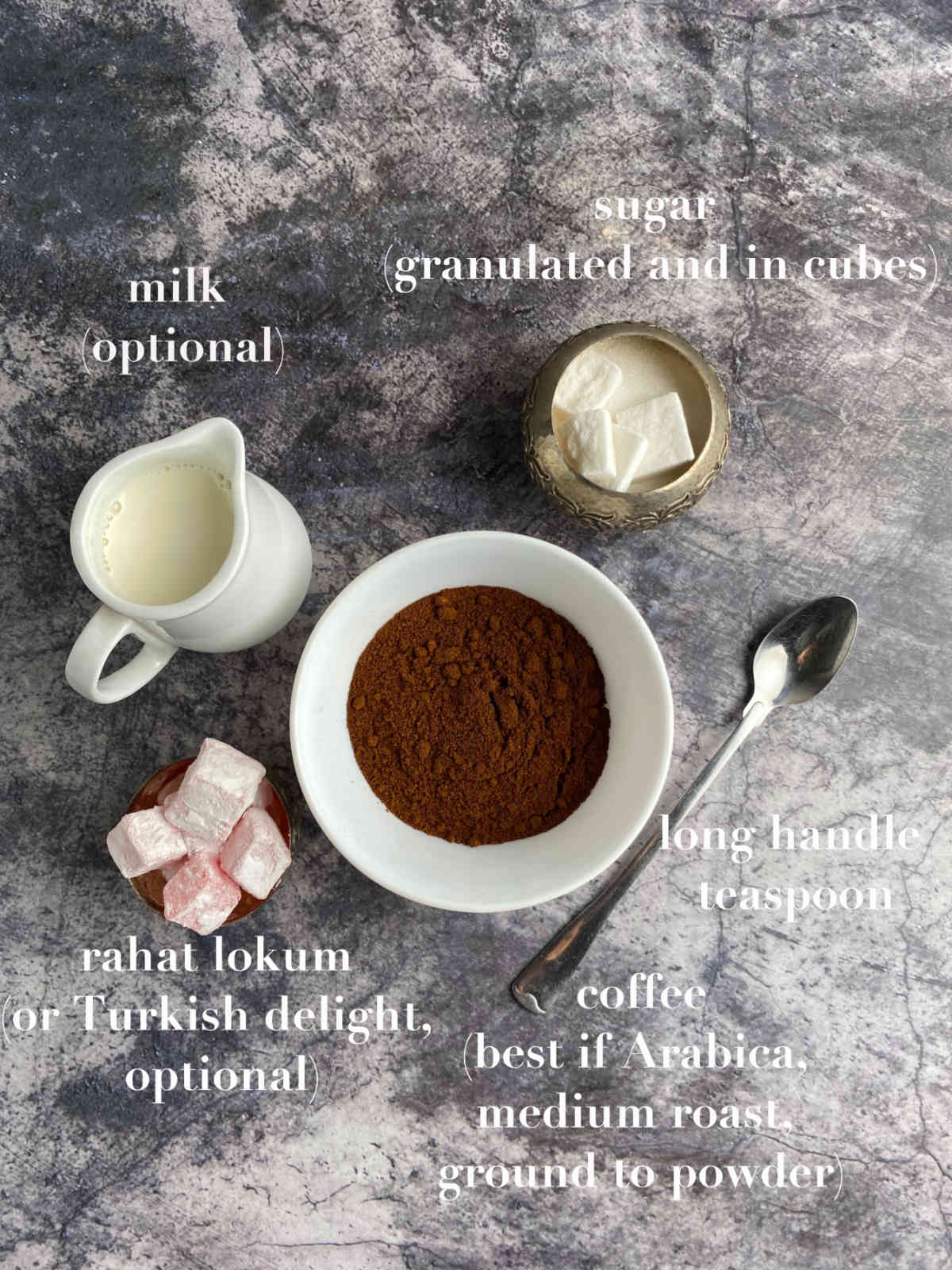 Ingredients for Bosnian coffee (coffee, sugar, spoon, rahat lokum) on gray marble background.