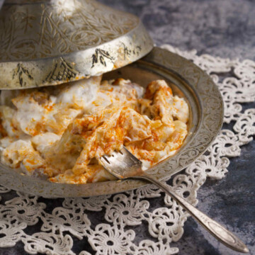 Bowl of klepe in traditional plating, on a gray background.