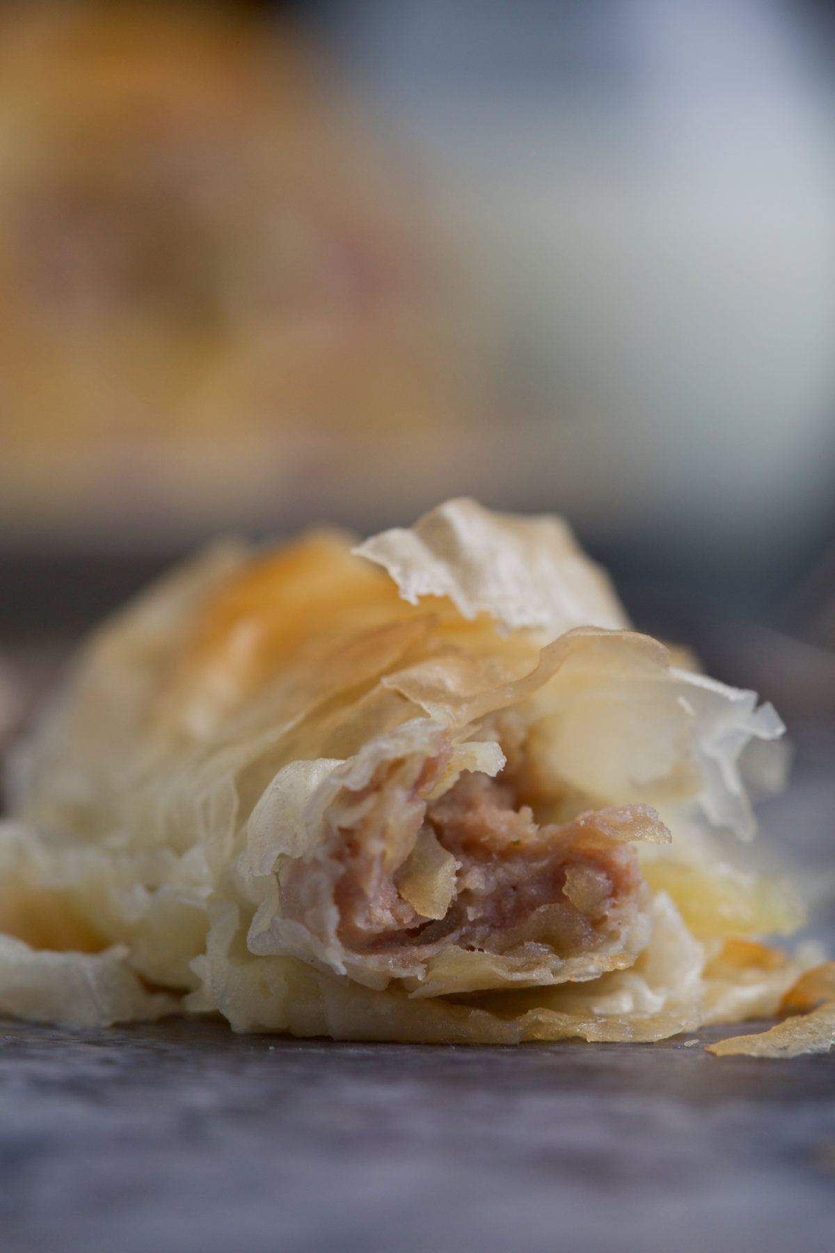A part of flaky pie on a heart-broken background.   Floor Pork and Potato Pie with Phyllo Rec ova2
