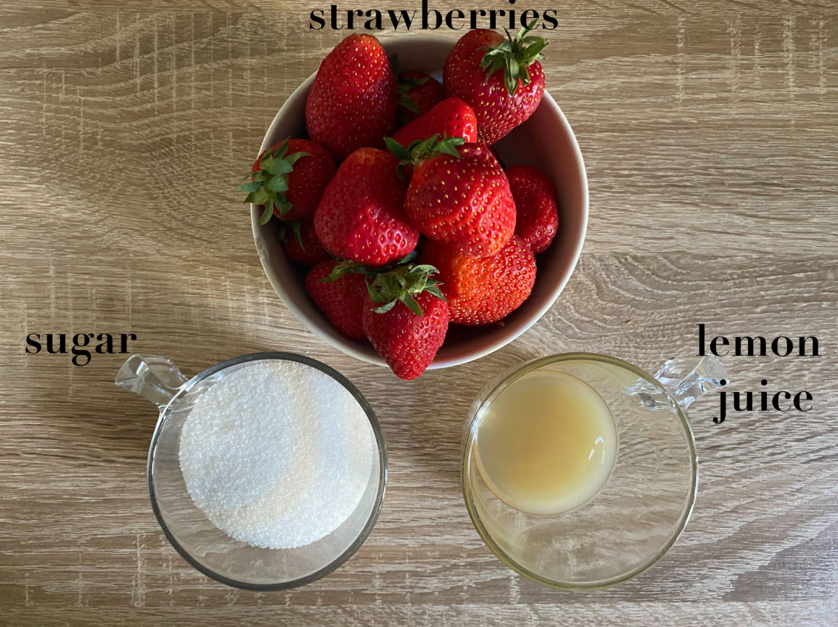 Strawberries, sugar and lemon juice on a table.