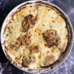 A pan with patties in bechamel on a blue marble background, overhead photo.