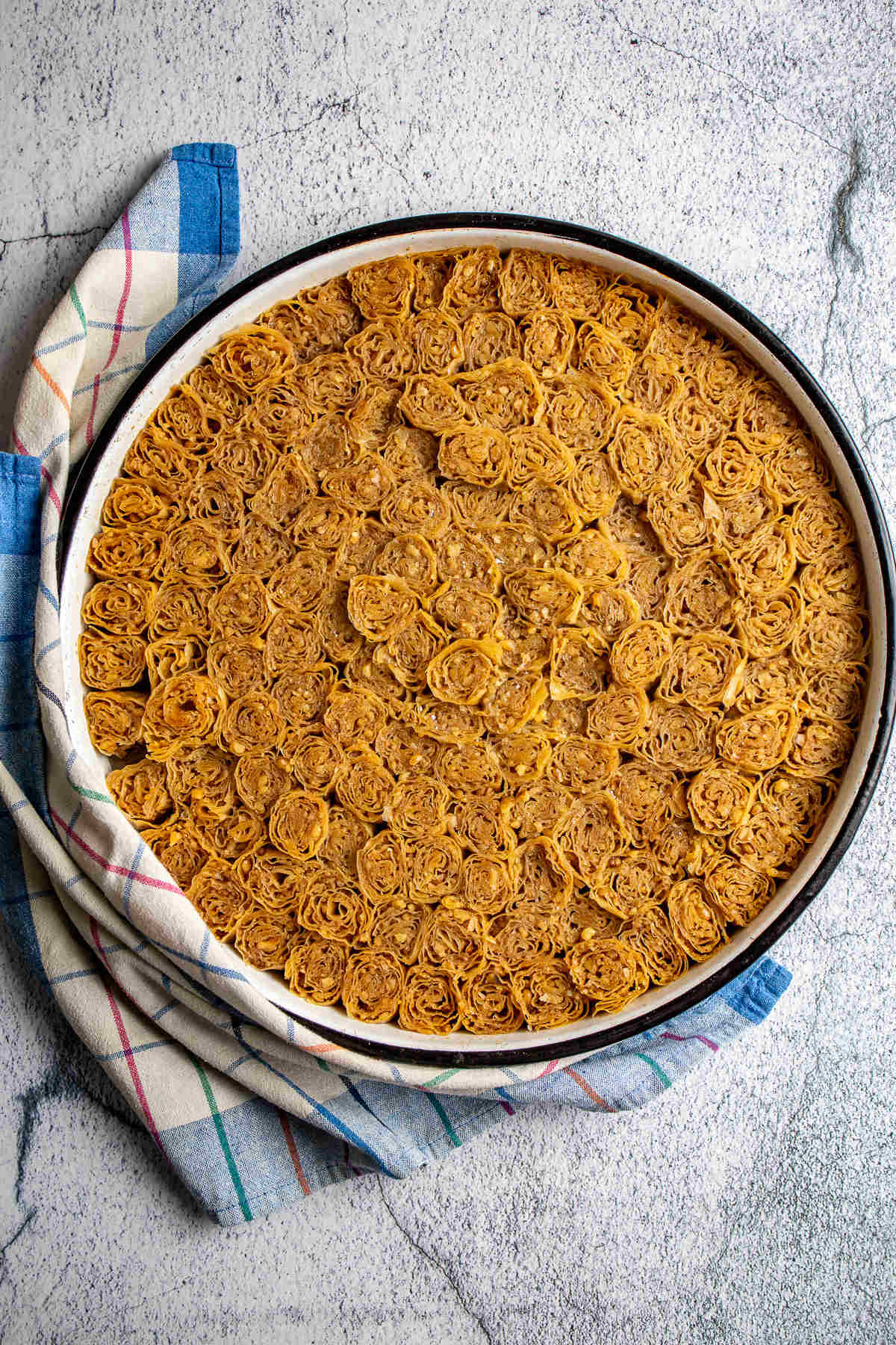 Round baking pan with 144 pieces of dessert in it. 