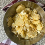 Bowl with potato salad on a granit background.