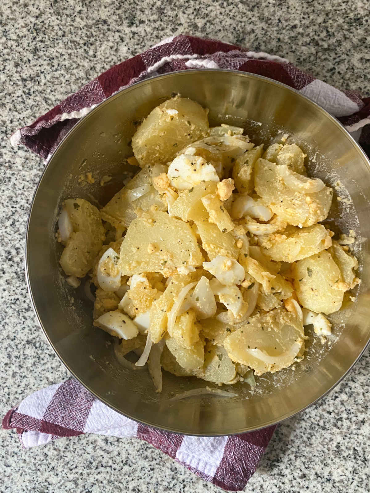 Bowl with potato salad on a granit background.