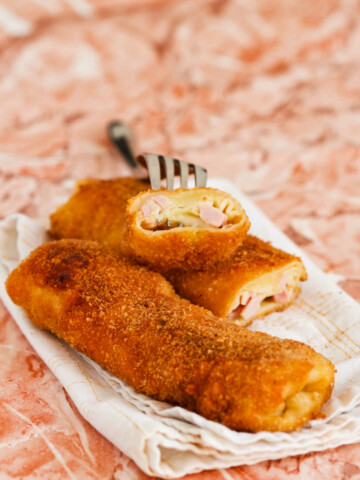 Breaded crepes on a table and a fork.