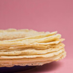 A plate of crepes on a pink background.