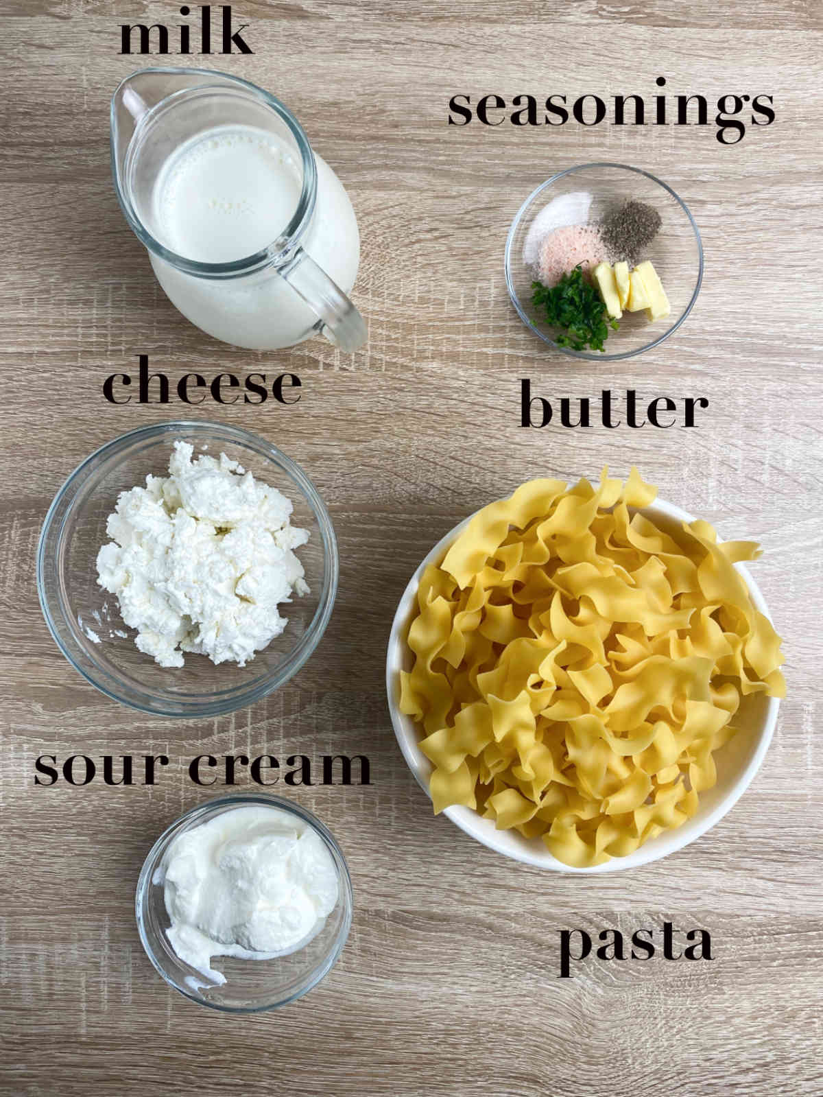 Overhead photograph of ingredients for the dish: pasta, milk, seasonings, butter, cheese and sour cream.
