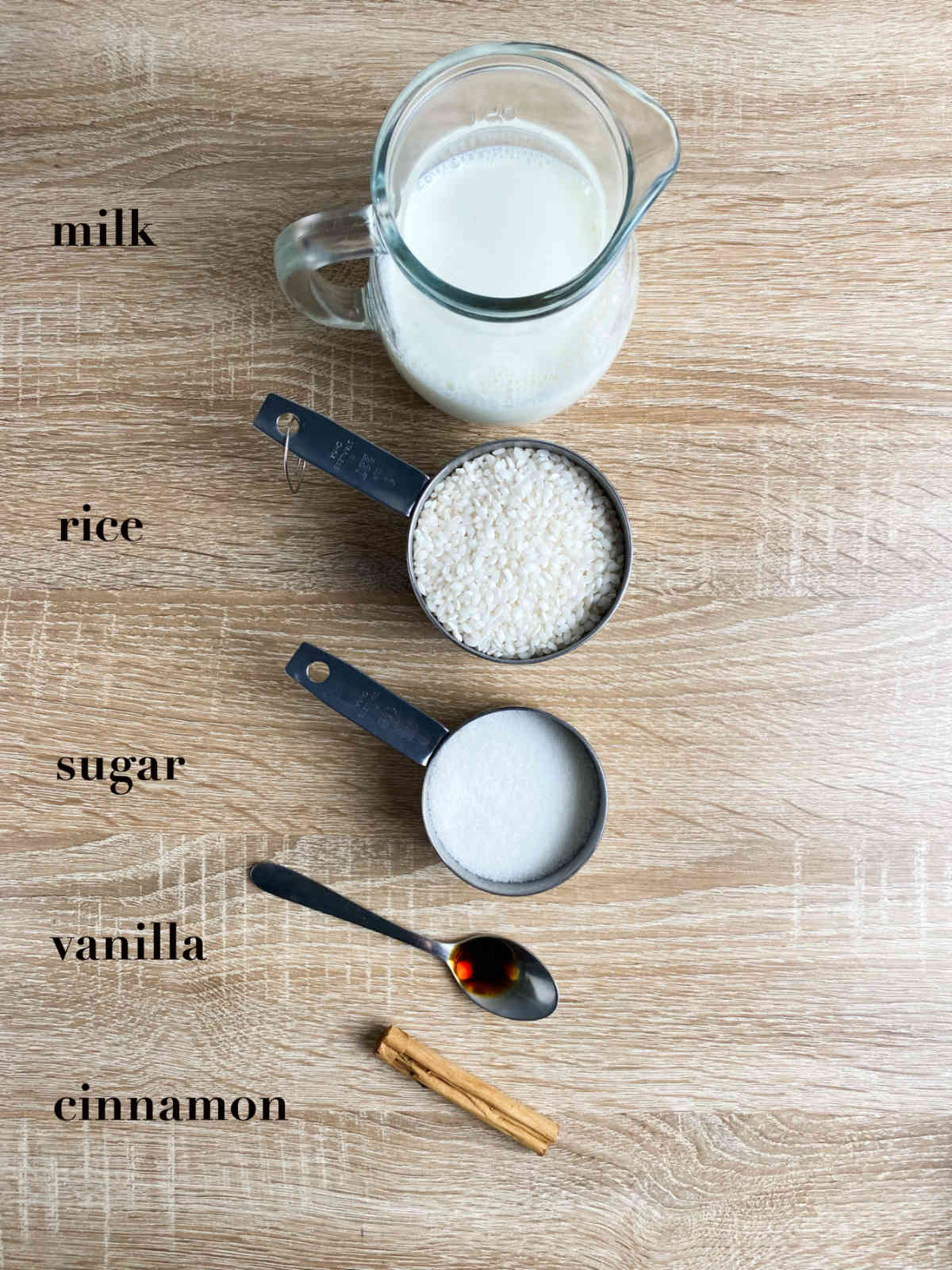 Ingredients for rice pudding: milk, rice, sugar, vanilla and cinnamon.