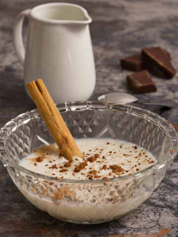 A bowl with rice pudding on a table.