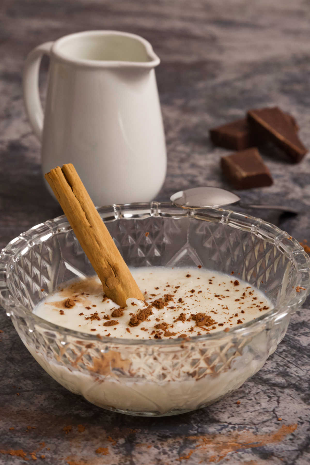 A bowl with rice pudding on a table. 