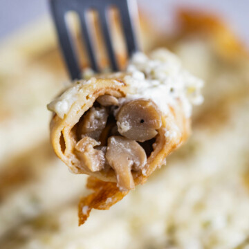 Closeup of a mushroom crepe on a fork.