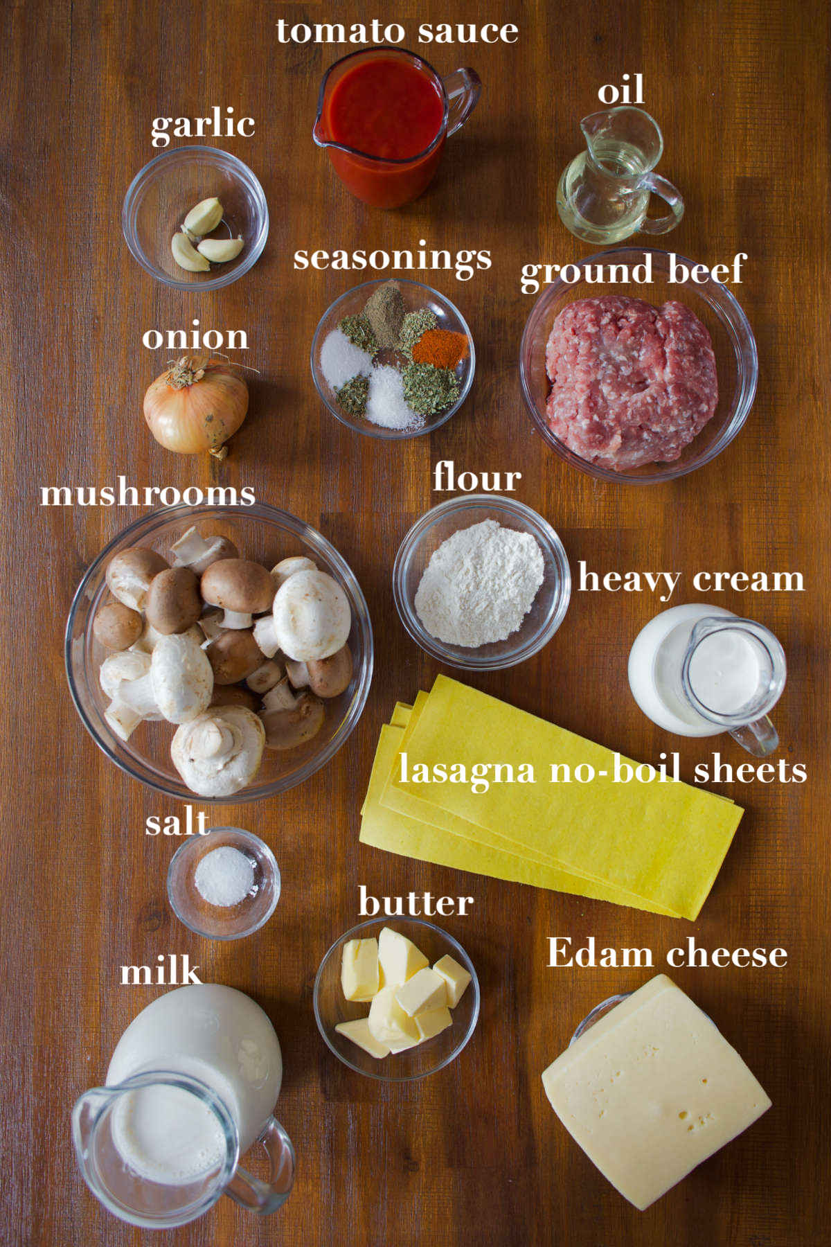 Lasagna ingredients on a wooden background. 