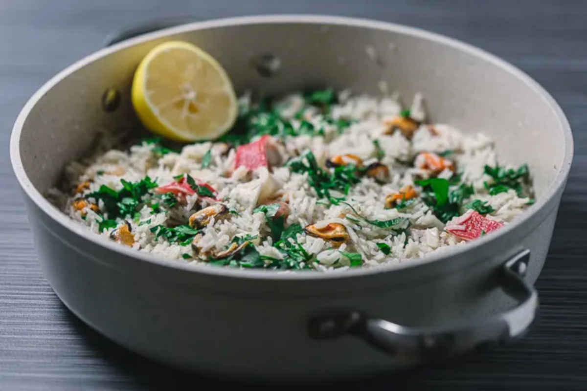 Seafood risotto in a wide beige pan. 