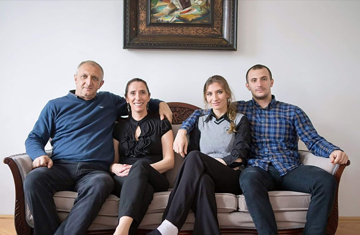 Four adults sitting on a couch. 