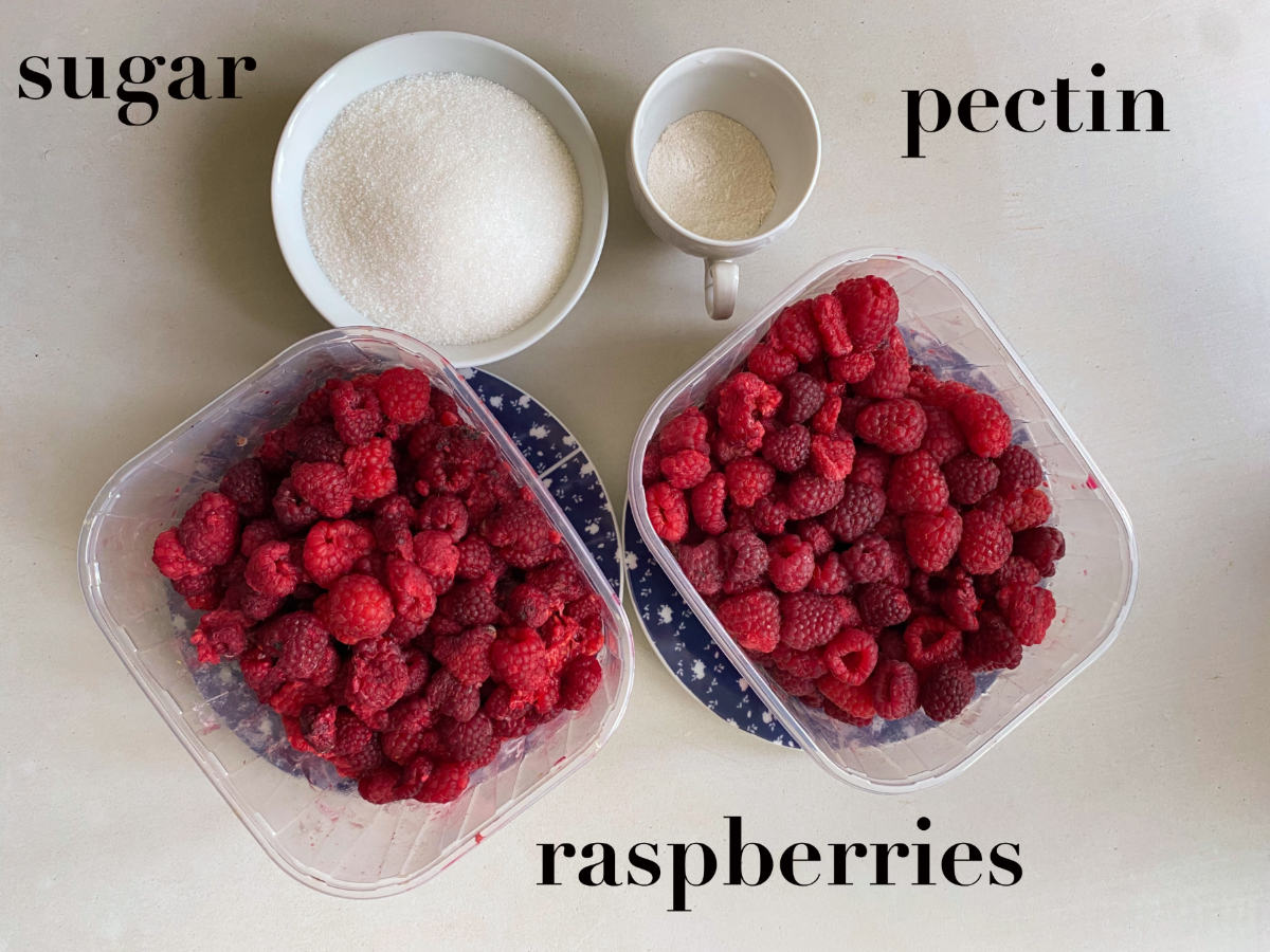 Raspberries, jam and pectin in bowls on a gray background. 