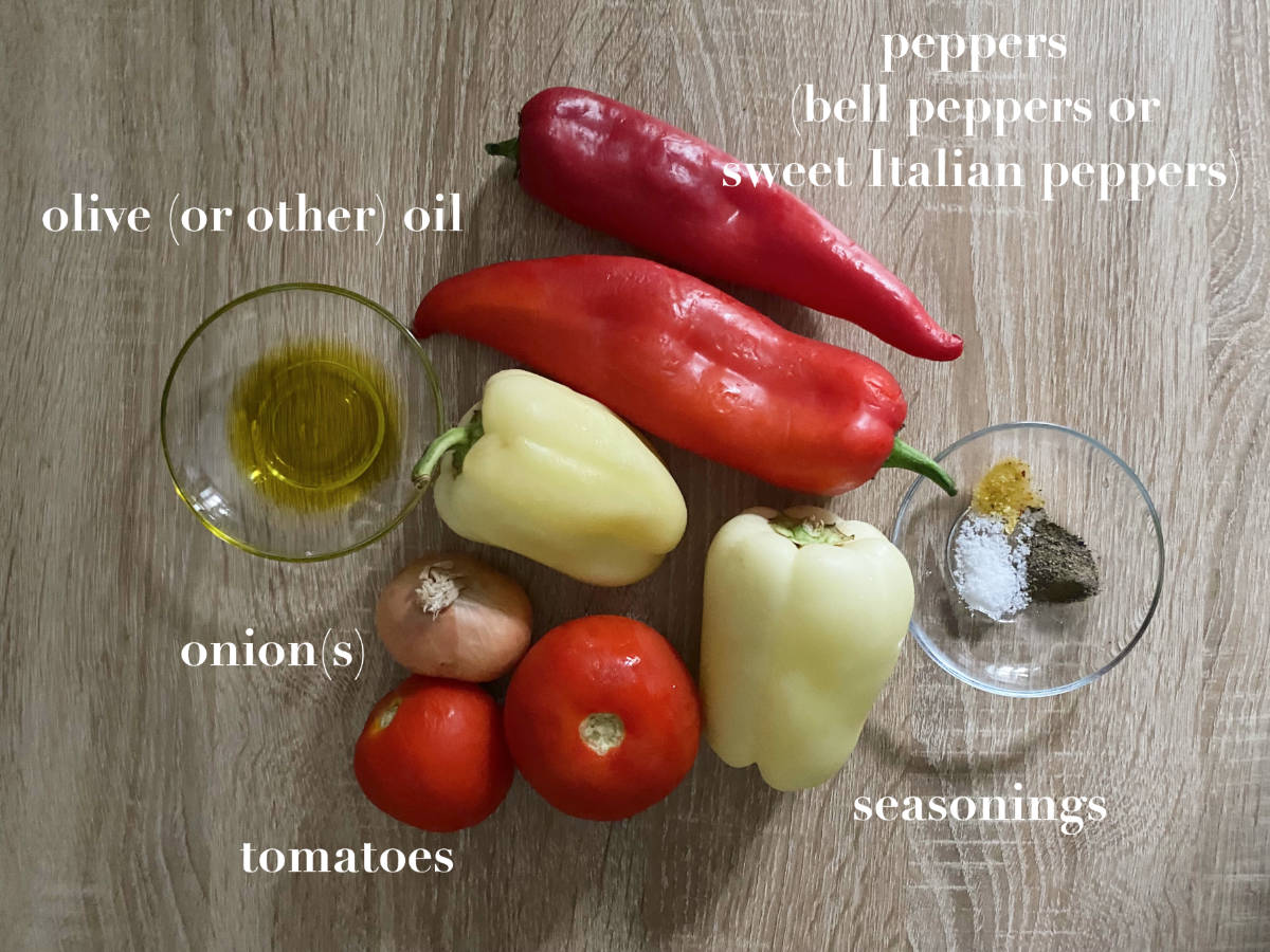 Overhead photo of peppers, tomatoes, onion, seasonings and oil on a wooden table.