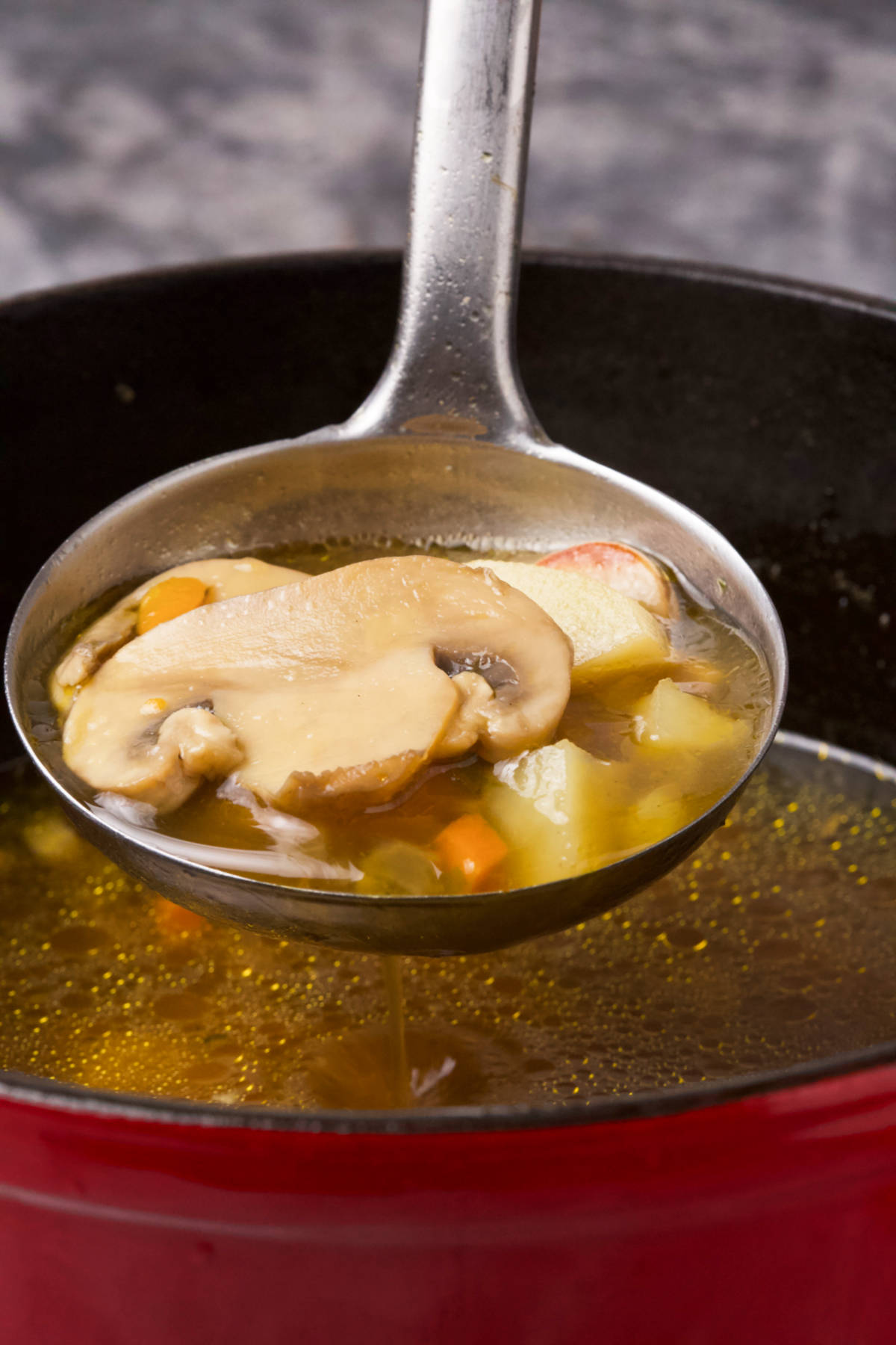 A ladle full of mushroom and potato soup.