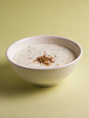 A bowl of tarator taratur soup (salad) on a green background.