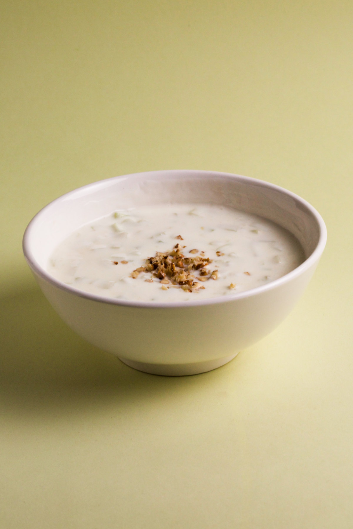 A bowl of tarator taratur soup (salad) on a green background.