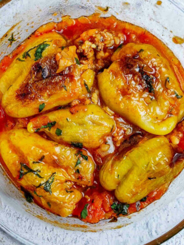 A glass bowl full of stuffed peppers.