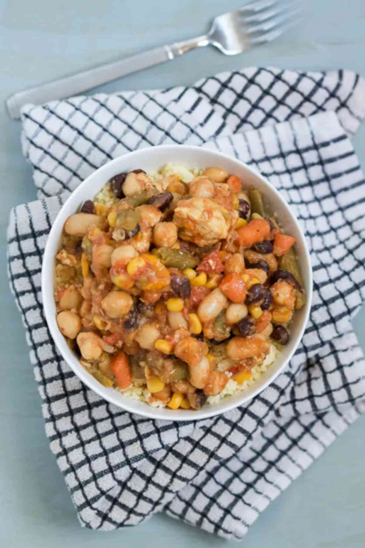 Bowl of couscous on a plaid kitchen towel. 